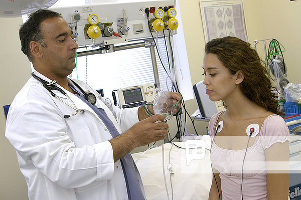 Ein Patient mit Atembeschwerden. Elektrokardiogramm und Anlegen einer Sauerstoffmaske.