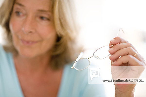 MODEL RELEASED. Reading glasses. Woman holding a pair of spectacles. Reading glasses