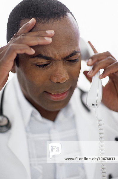 MODEL RELEASED. Male doctor making a telephone call. Male doctor