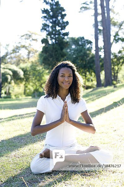 MODELL FREIGEGEBEN. Meditation. Frau meditiert mit zusammengelegten Händen. Sie sitzt im Lotussitz Meditation