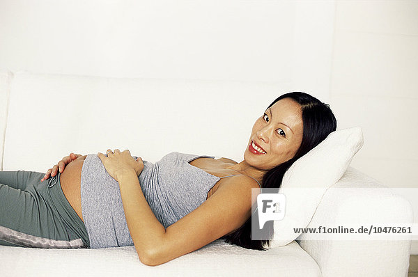 MODELL FREIGEGEBEN. Schwangere Frau entspannt sich. Sie ist im achten Monat (33 Wochen) schwanger. Schwangere Frau entspannt