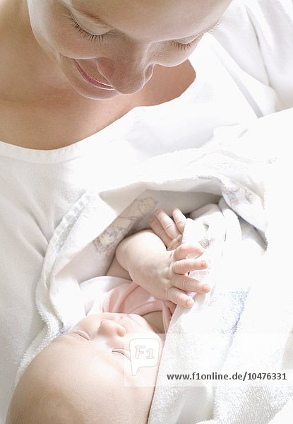 MODEL RELEASED. Mother and newborn baby. Woman in a maternity ward holding her newborn baby. Mother and newborn baby