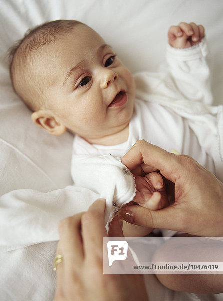 MODEL RELEASED. Baby girl. 12-week-old baby girl having her clothes changed. Baby girl