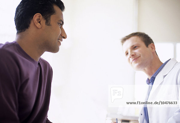 MODEL RELEASED. Medical consultation. General practice doctor talking to a male patient. Medical consultation