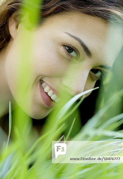 MODELL FREIGEGEBEN. Frau lächelt durch Gras Frau lächelt durch Gras