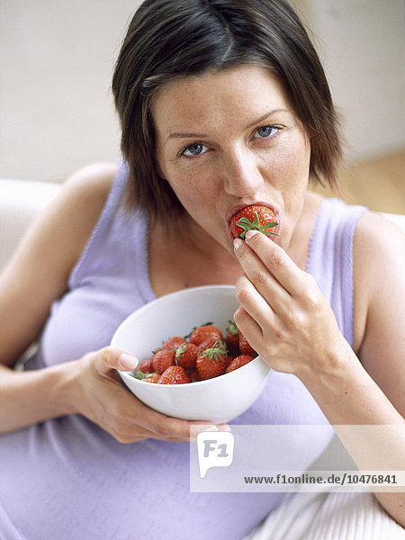 MODELL FREIGEGEBEN. Gesunde Ernährung. Frau isst Erdbeeren. Erdbeeren sind reich an Mineralien und Vitamin C und enthalten wenig Fett. Gesunde Ernährung