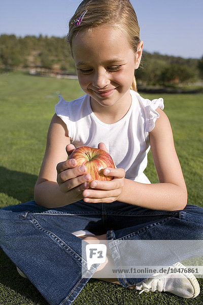 MODEL RELEASED. Girl holding an apple. This fruit is a good source of vitamin C. Fruit is a also a good source of minerals and fibre. Girl holding an apple