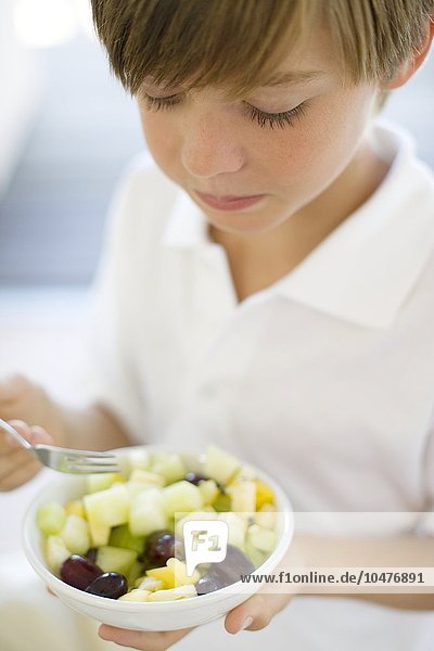 MODELL FREIGEGEBEN. Gesunde Ernährung. 10 Jahre alter Junge isst einen Obstsalat Gesunde Ernährung
