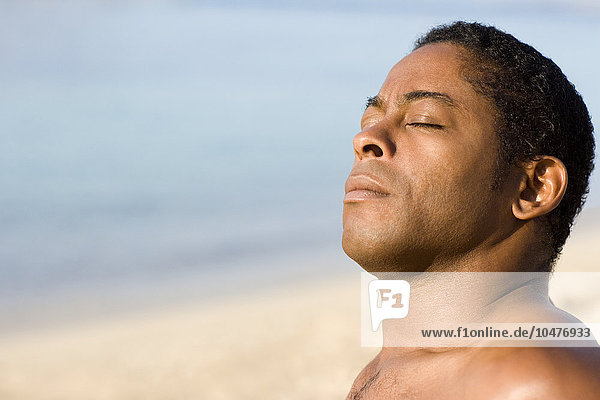 MODELL FREIGEGEBEN. Mann beim Sonnenbaden am Strand Mann beim Sonnenbaden