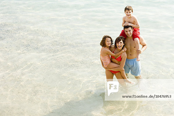MODELL FREIGEGEBEN. Familie im Urlaub stehend im Meer Familie im Urlaub