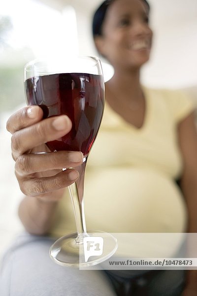 Schwangere Frau mit einem Glas Rotwein