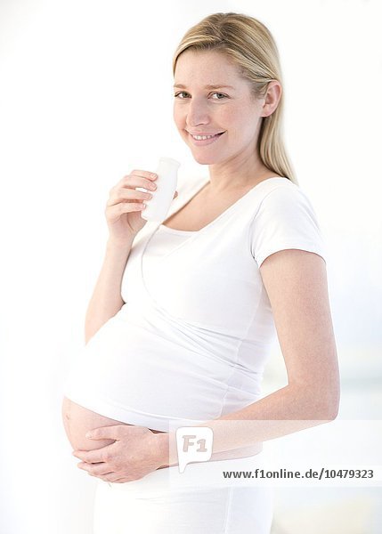 Schwangere Frau trinkt Milch