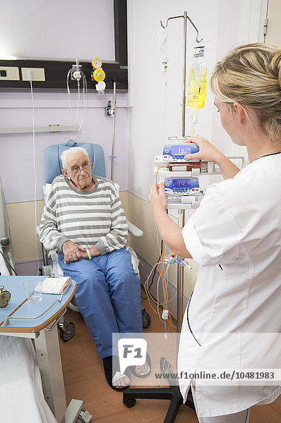 Reportage in the Geriatrics service in Saint-Vincent de Paul hospital in Lille  France. A nurse adjusts a patient?s syringe pump in his hospital room.