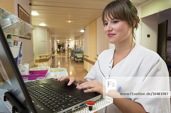 Reportage in the Geriatrics service in Saint-Vincent de Paul hospital in Lille  France. A nurse adds to a patient?s computer file in one of the hospital corridors.