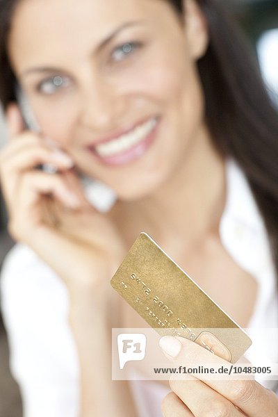 MODELL FREIGEGEBEN. Kauf mit Kreditkarte. Frau  die eine Kreditkarte benutzt  um einen Kauf über das Telefon zu tätigen Kauf mit Kreditkarte