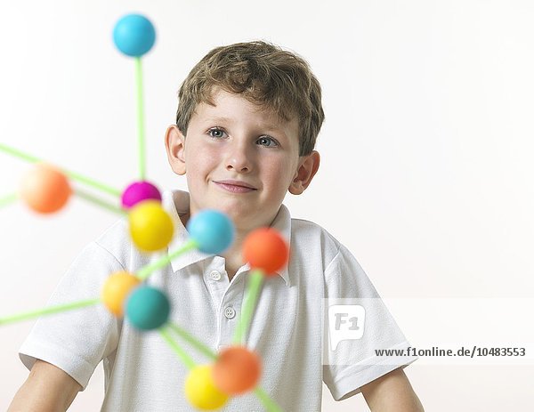 MODELL FREIGEGEBEN. Chemieunterricht. 6-jähriger Junge beim Betrachten einer Molekularstruktur Chemiestunde