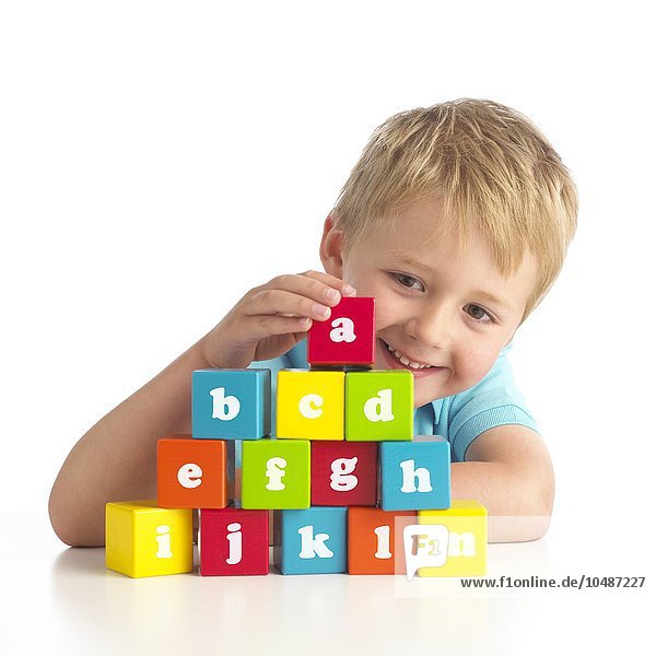 Junge spielt mit Buchstabenblöcken Junge spielt mit Buchstabenblöcken