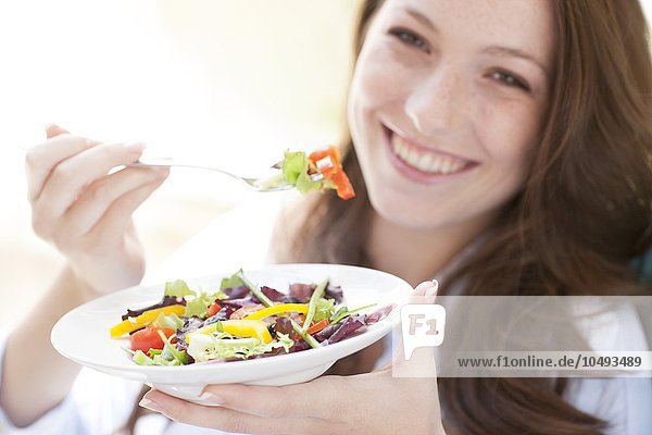 MODEL RELEASED. Young woman eating a salad. Young woman eating a salad