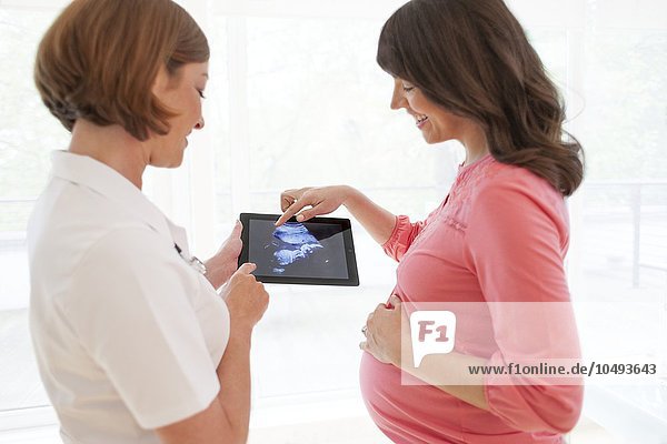 MODEL RELEASED. Pregnant woman with baby scan. Pregnant woman with baby scan