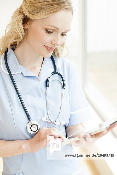 MODELL FREIGEGEBEN. Krankenschwester  die einen Tablet-Computer benutzt Krankenschwester  die einen Tablet-Computer benutzt