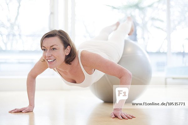 MODEL RELEASED. Woman balancing on an exercise ball. Woman on exercise ball