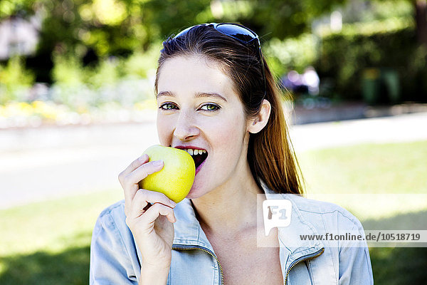 Frau isst einen Apfel.