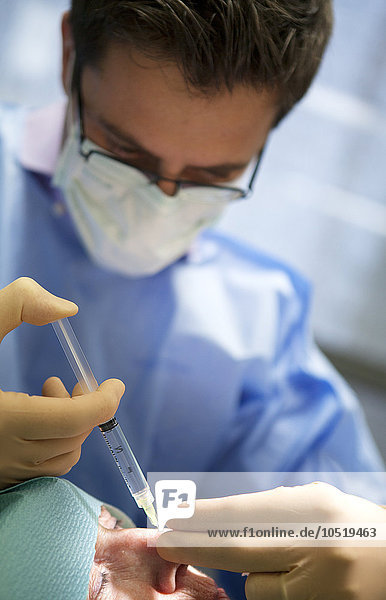 Reportage in einer dermatologischen Praxis in Genf  Schweiz. Der Dermatologe entfernt ein verdächtiges Muttermal aus der Nase des Patienten.