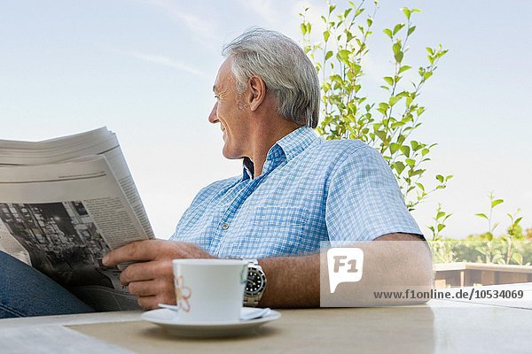 Älterer erwachsener Mann beim Lesen einer Zeitung