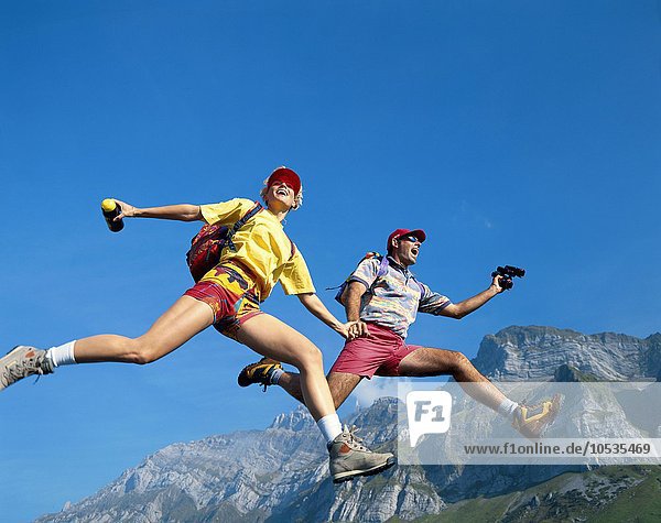 10371166  Berge  Überblick  Bergwandern  dynamisch  glücklich  fröhlich  Kapriolen  Sprungpaar  Paar  Rucksack  Santis  S