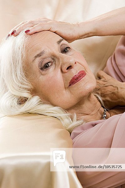 Glamouröse Seniorin auf Satin liegend