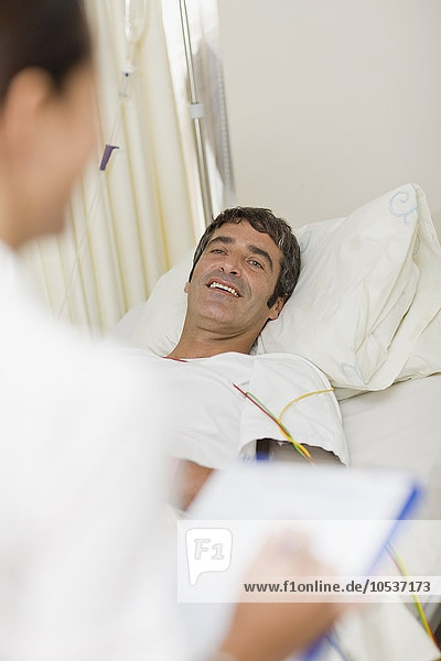 Patient mit Arzt im Krankenhausbett