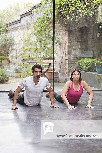 Paar  das zu Hause gemeinsam Yoga praktiziert