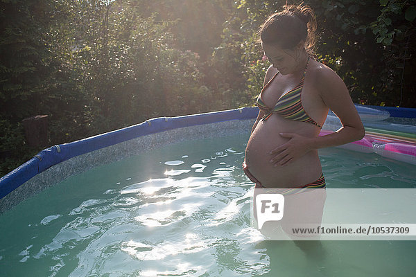 Schwangere Frau im Pool stehend