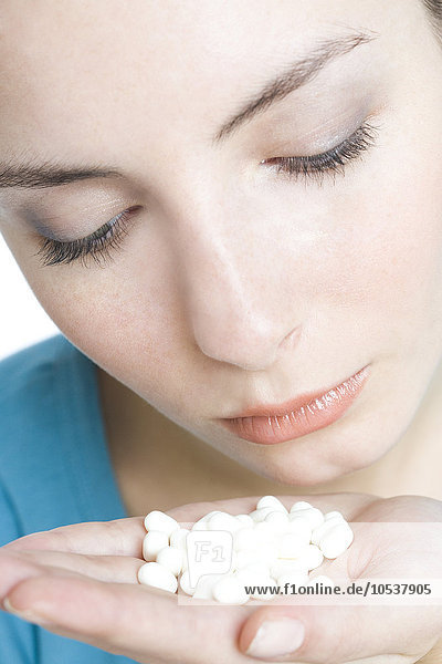 young woman with pills on hand