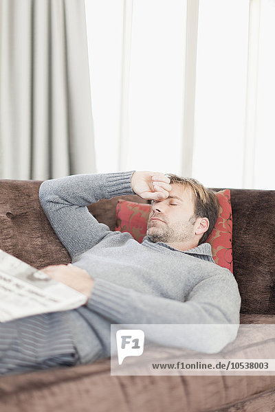 Man with headache resting on couch