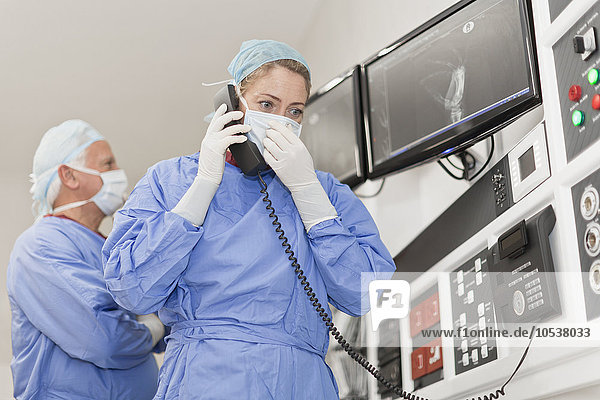 Arzt am Telefon im Operationssaal