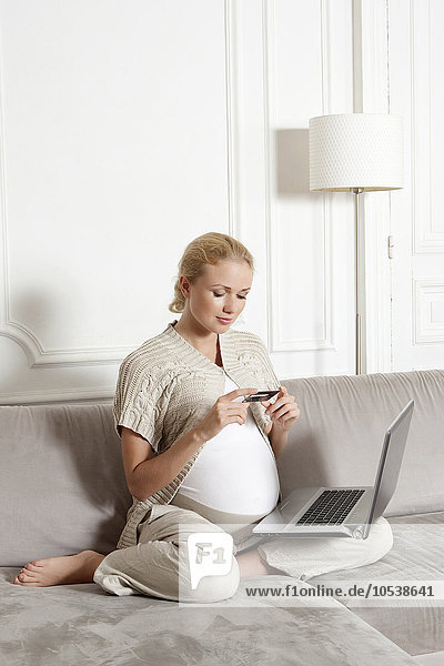 Schwangere Frau beim Online-Shopping