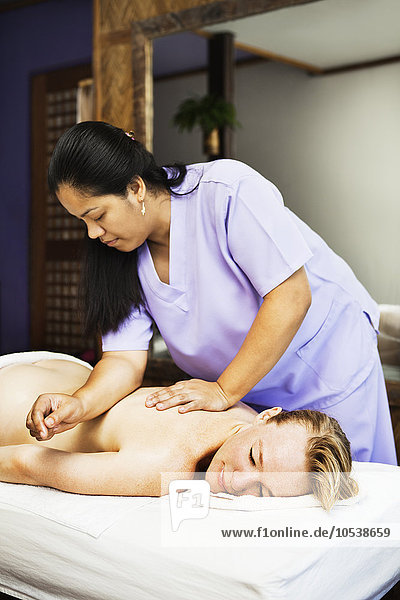 Woman having back massage in spa