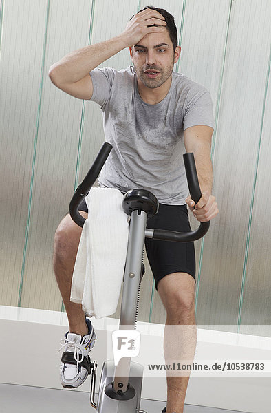 Struggling man using exercise machine
