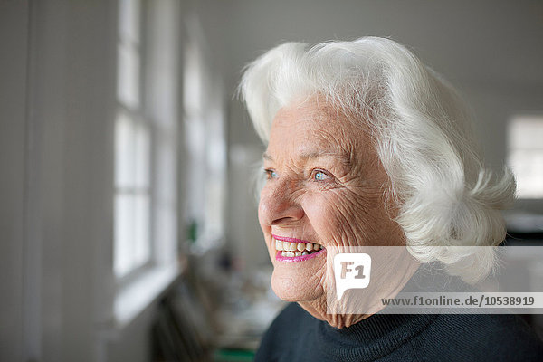 Porträt einer älteren Frau mit Blick aus dem Fenster