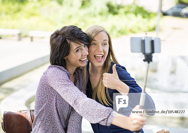Zwei junge Frauen albern für Selfie