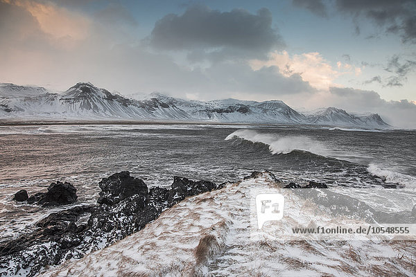 Schneebedeckte Bergkette über dem kalten Meer  Budir  Snaefellsnes  Island