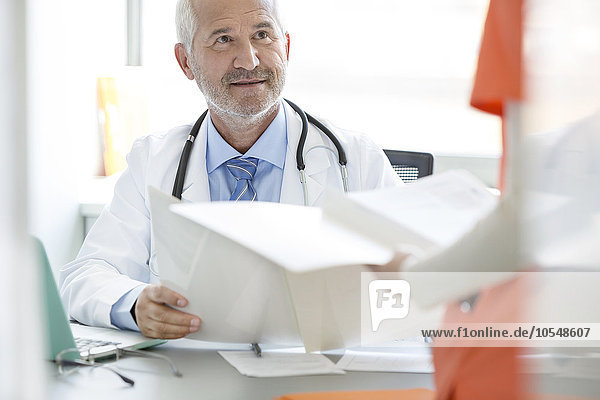 Doctor and nurse reviewing medical record in doctor’s office