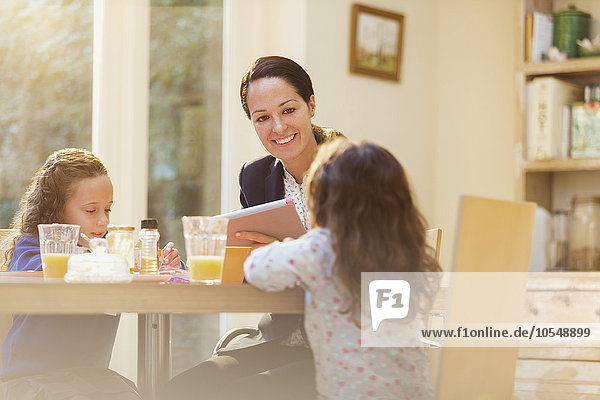 Working mother and daughters at breakfast table