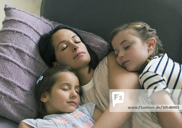Gelassene Mutter und Töchter beim Schlafen auf dem Sofa