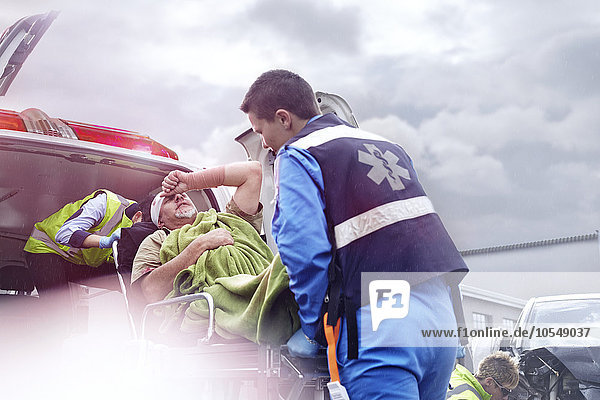 Rettungskräfte beim Verladen des Unfallopfers in den Krankenwagen