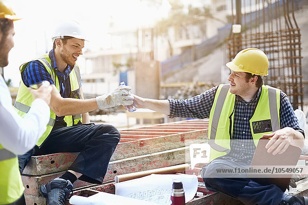 Bauarbeiter und Ingenieur genießen Kaffeepause auf der Baustelle