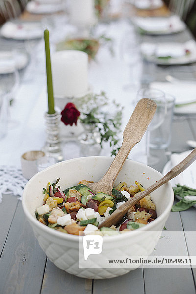 Eine Schüssel Salat auf einem Tisch in einem Garten.