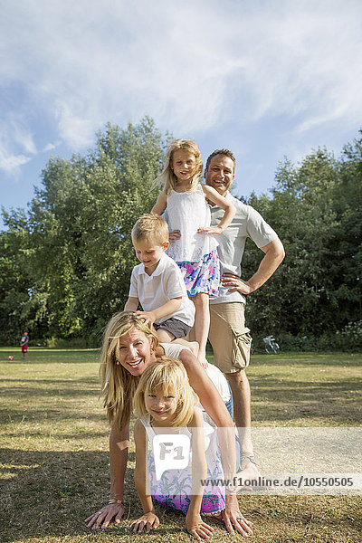 Family with three children playing in a park.