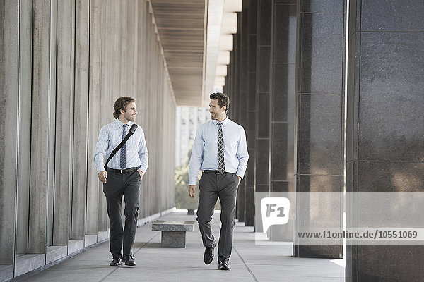 Two businessmen walking along a city street.
